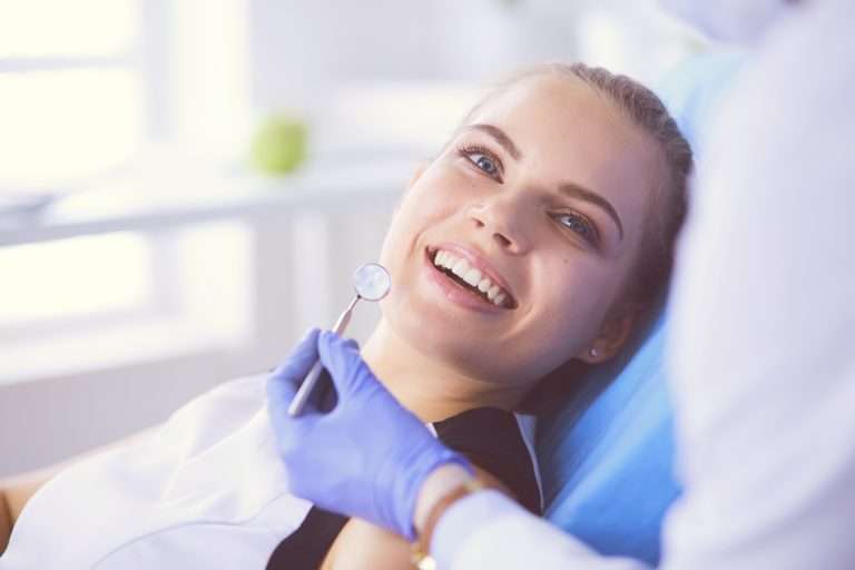Smiling woman in dental chair during a checkup with a dentist
